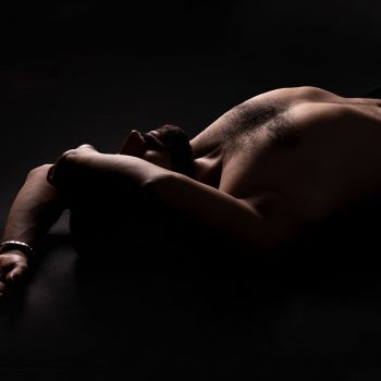 Hautnah Tantra Ulm Masseur Sharif liegt mit nacktem Oberkörper